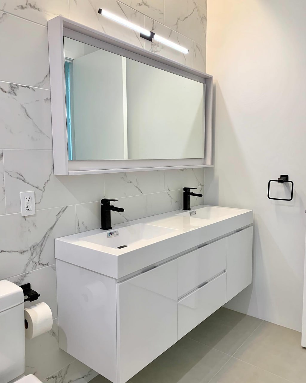 Marble bathroom vanity with black fixtures installed by ReDesignFix