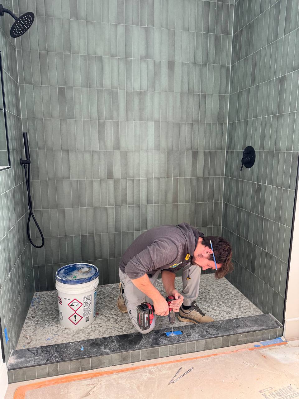 ReDesignFix crew member installing tile in a shower