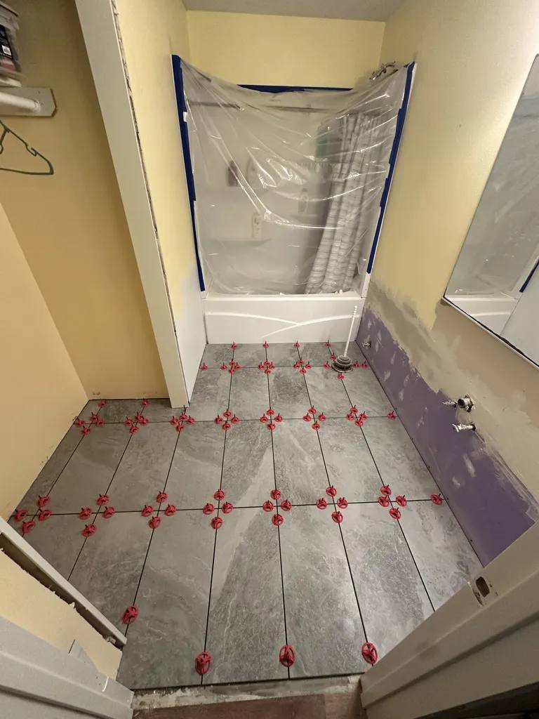 Bathroom tile flooring installation with leveling spacers