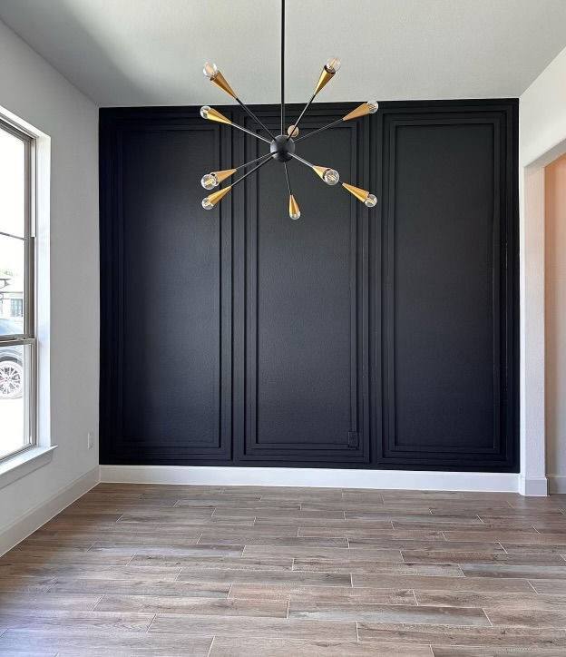 Living room with black accent wall and new wood-tone flooring